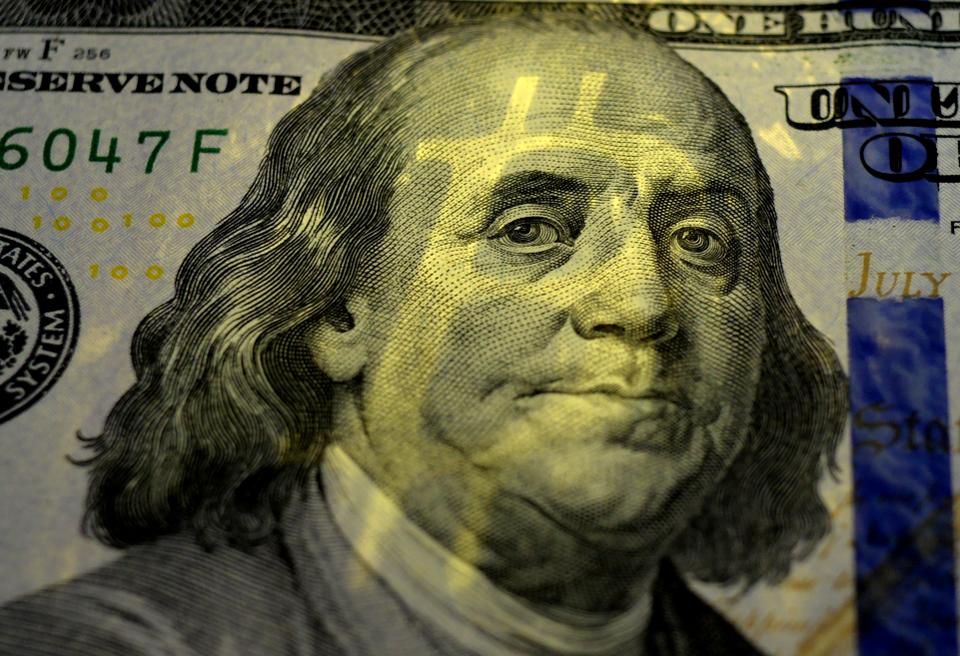 美国一百美元本杰明·富兰克林脸上的比特币阴影。金钱观。