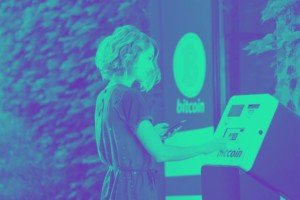 比特币ATM越来越受欢迎。图中是一个操作比特币机器的女人。